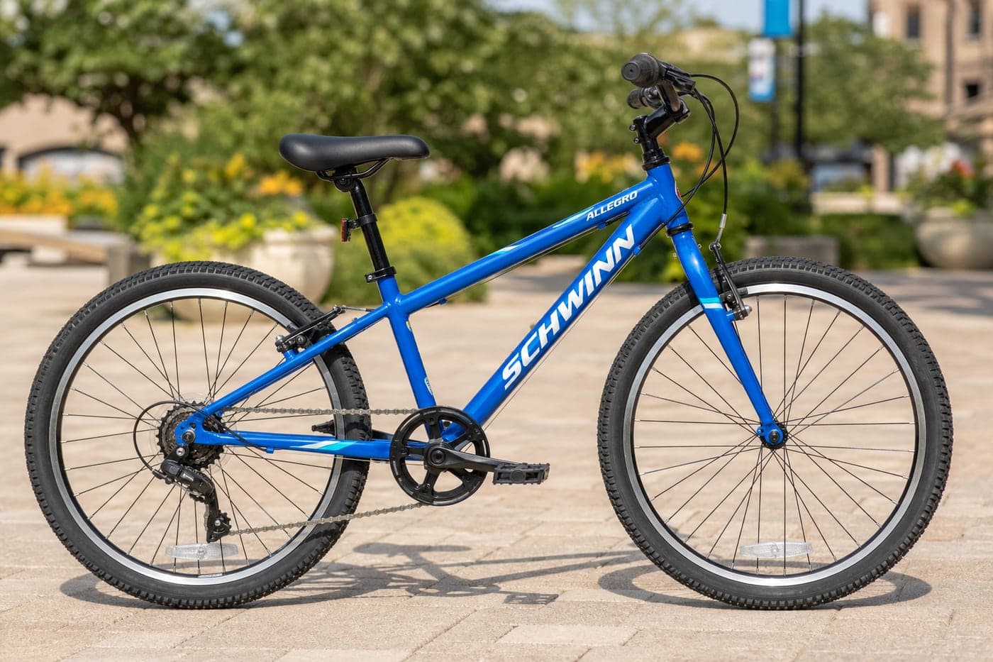 24 inch blue kids cycle standing on a sunny plaza outdoors